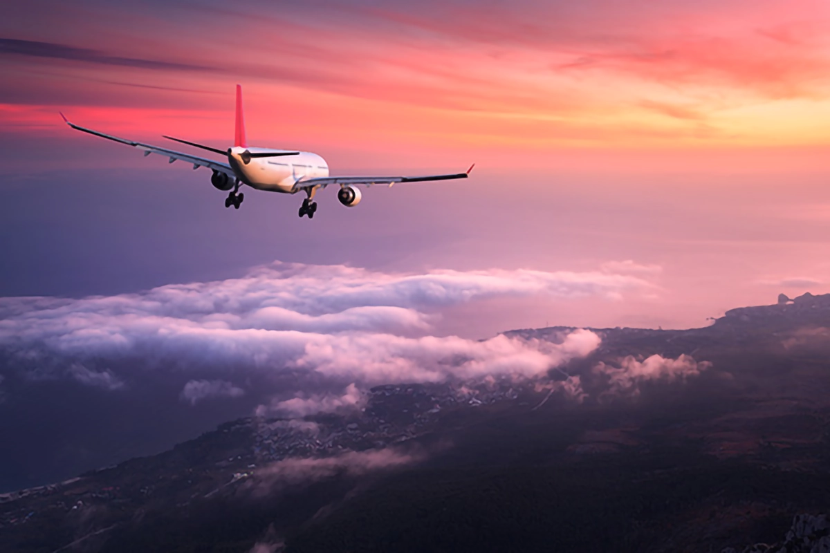 Image of a plane landing at an airport in a sunset